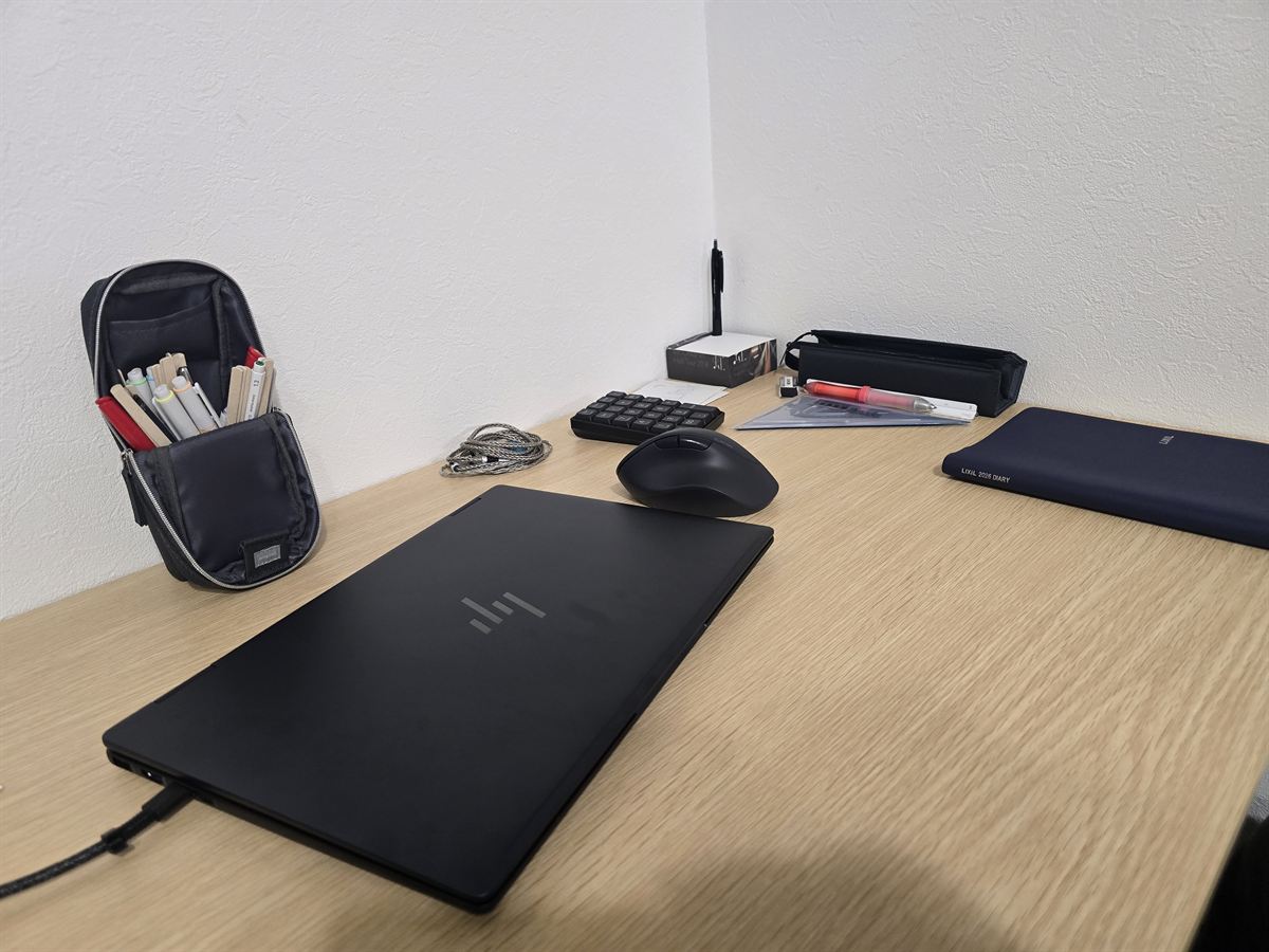 現在の仕事机。ノートパソコンと筆記具